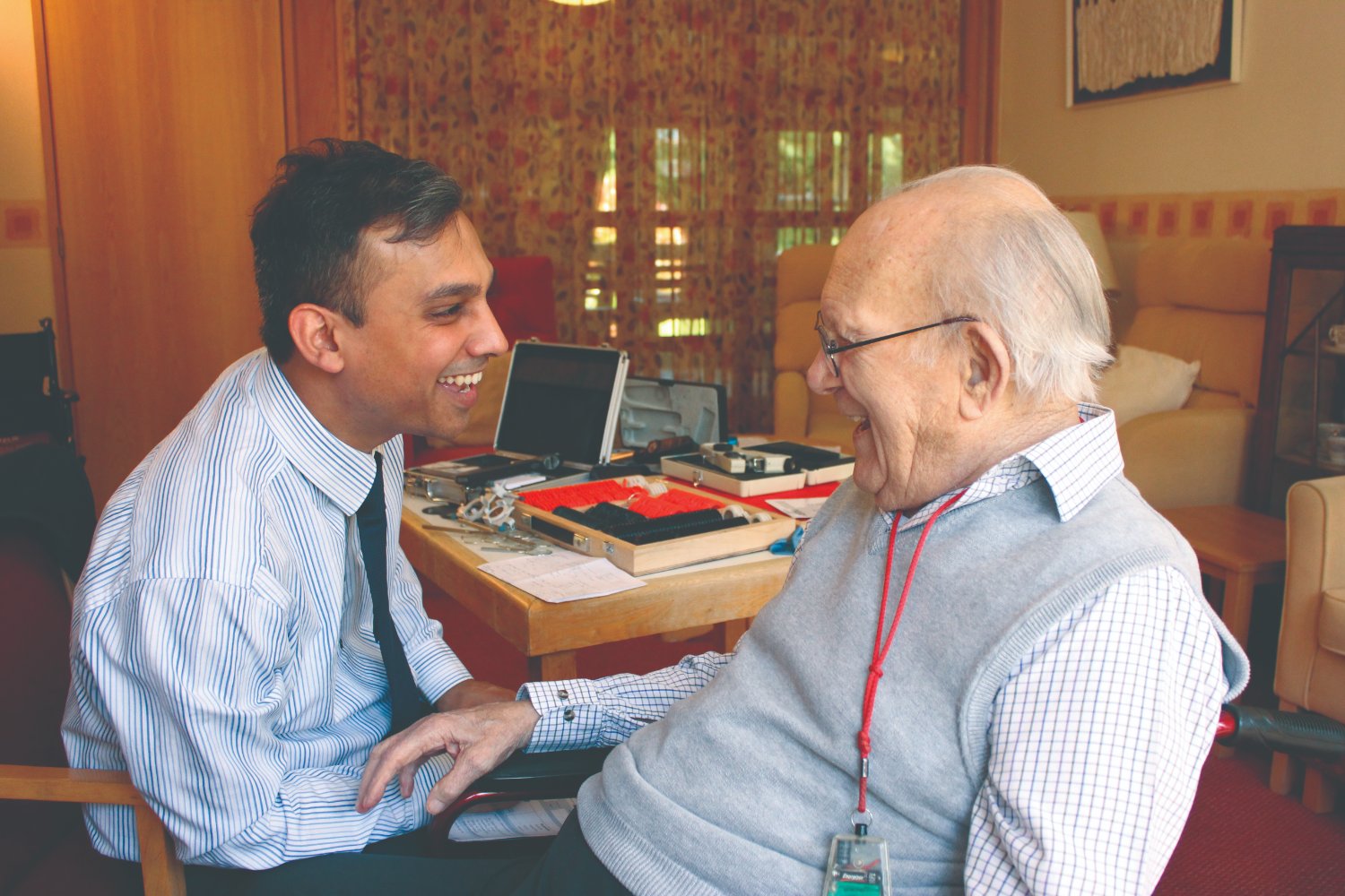 An Opticall optometrist adapting an eye test using portable equipment in a resident's room